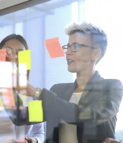 woman-putting-up-sticky-notes woman-putting-up-sticky-notes