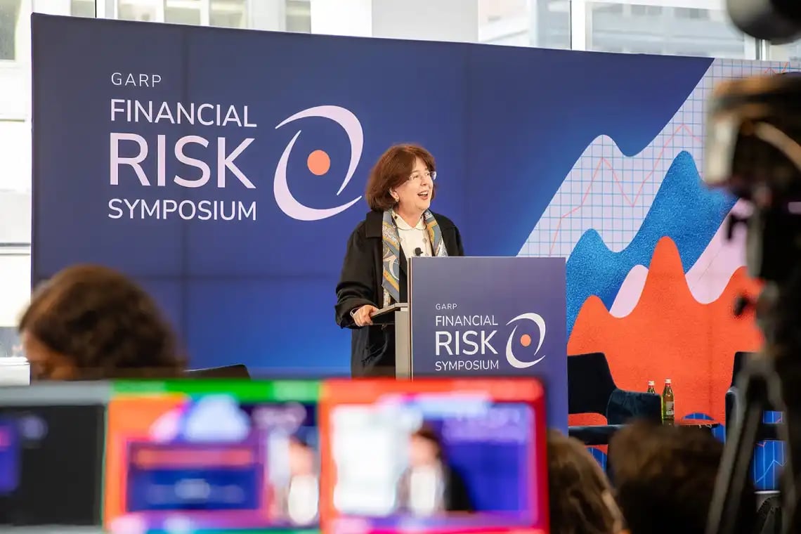 woman-speaking-at-finanical-risk-symposium woman-speaking-at-finanical-risk-symposium